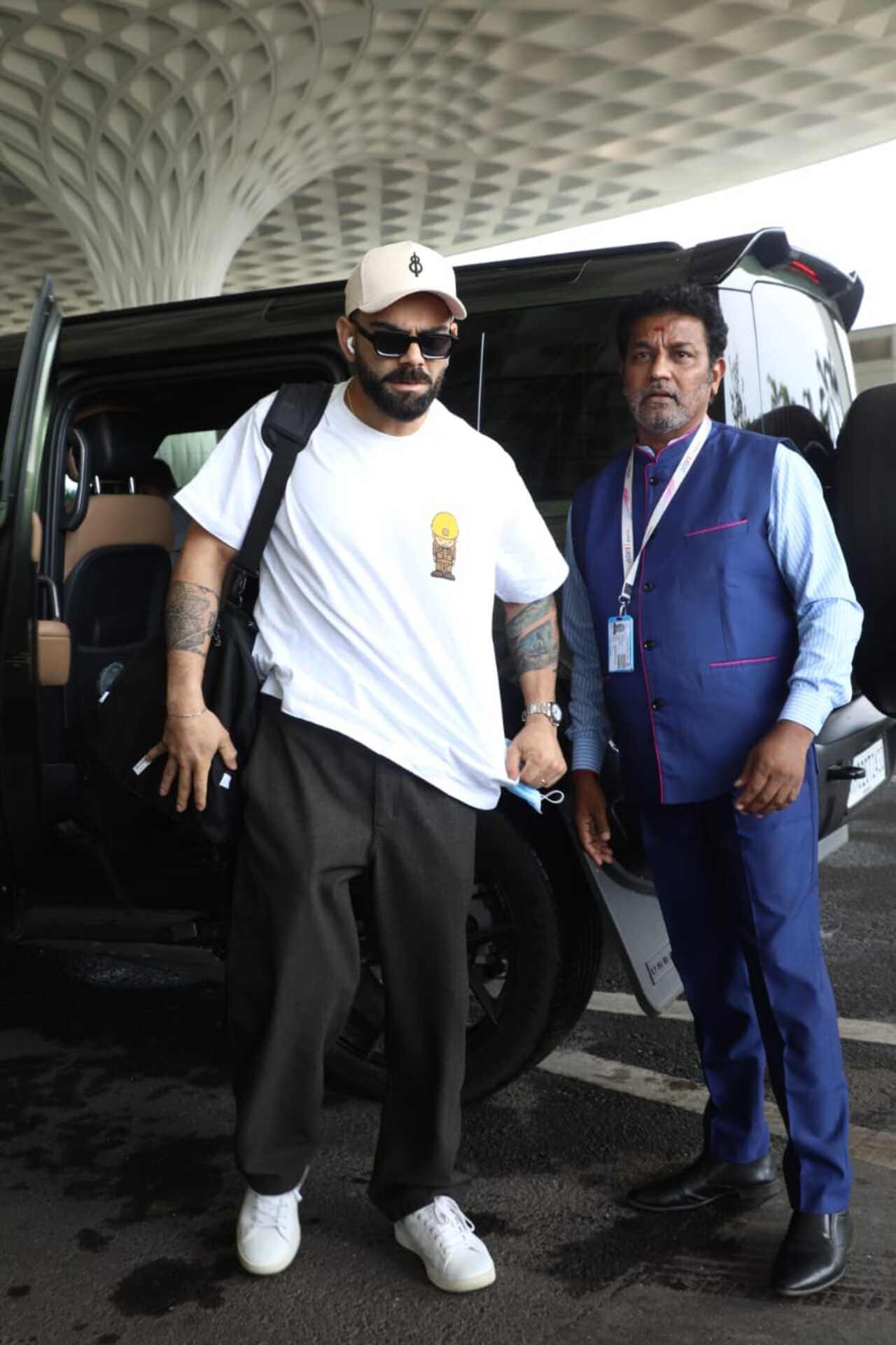 Virat Kohli was seen at the airport on Wednesday morning as he headed out of the city in a white oversized t-shirt, a matching cap, and black track pants. Virat Kohli was seen at the airport on Wednesday morning as he headed out of the city in a white oversized t-shirt, a matching cap, and black track pants.